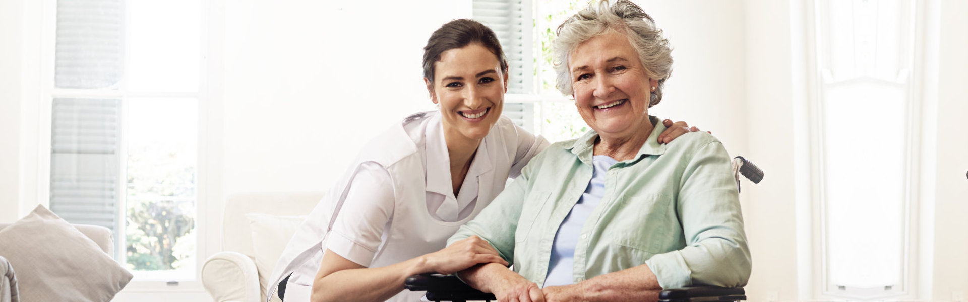 caregiver and an erderly woman smiling