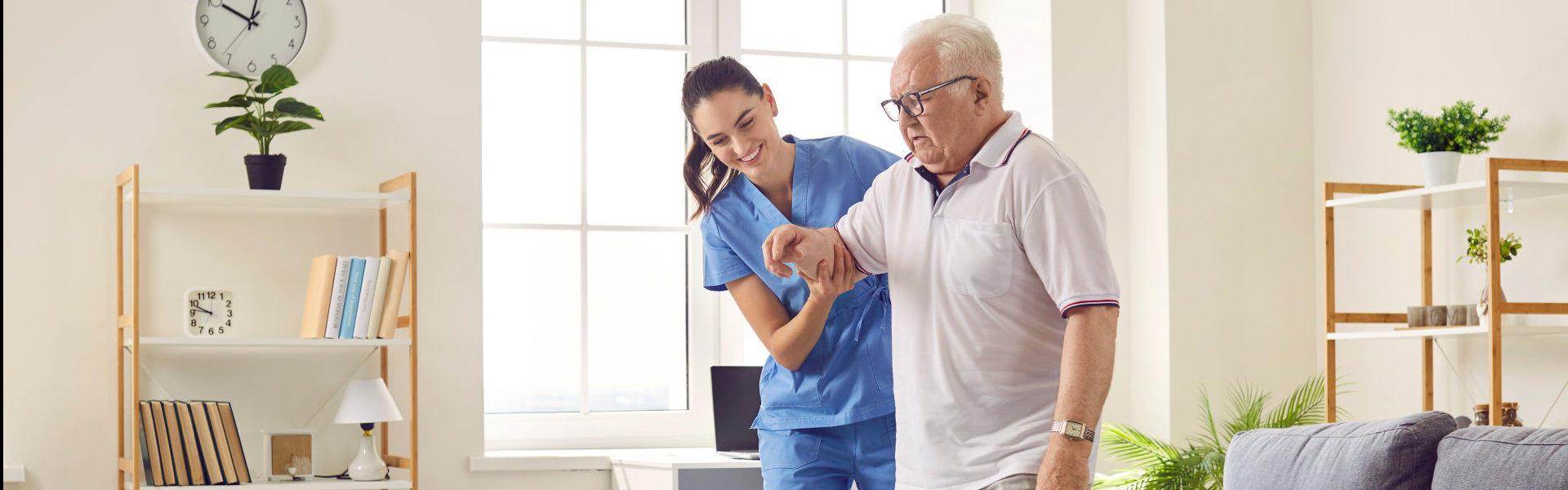 caregiver helping an erderly man to walk